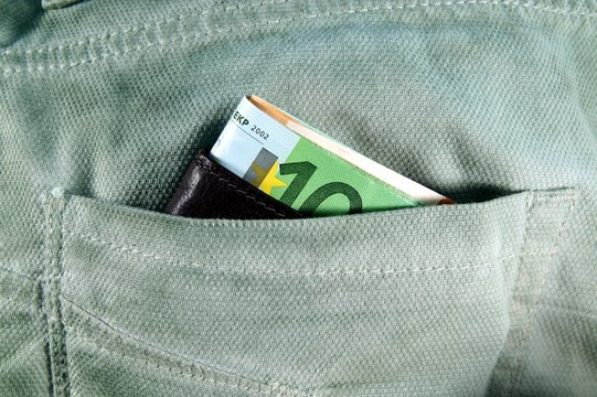 euro money cash, euro banknotes in the leather wallet in the pockets of trousers. banner for web, gift card, postcard. Concept of wealth, saving or spending money. Easy to steal the money. falling out