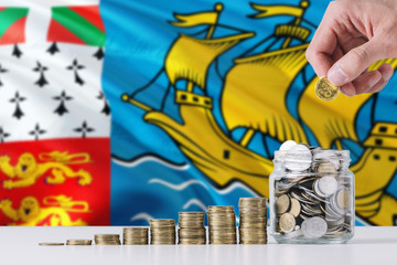 Business man holding coins putting in glass, Saint Pierre And Miquelon flag waving in the background. Finance and business concept. Saving money.
