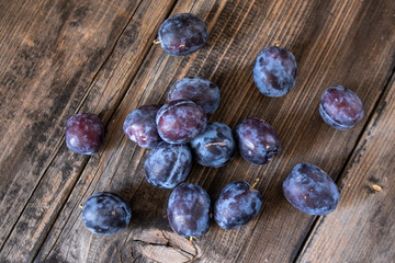 Fresh organic plums on old wooden table.