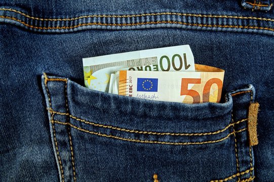 euro money cash, euro banknotes in the pockets of jeans trousers. banner for web, gift card, postcard. Concept of wealth, saving or spending money. Euro bills falling out. Easy to steal the money.