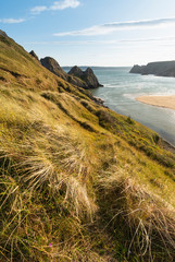 Beautiful peaceful Summer evening sunset beach landscape image at Three Cliffs Bay in South Wales