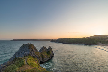 Fototapeta na wymiar Beautiful peaceful Summer evening sunset beach landscape image at Three Cliffs Bay in South Wales