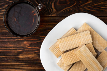 Vanilla wafer biscuit on dark wooden background.