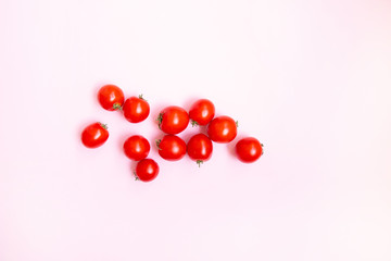 Fresh cherry tomato on soft gentle pink background.