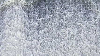 Water stream in dam of hydroelectric station flowing with bubbles