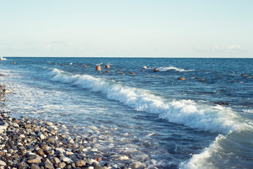 Light waves on the rocky seashore at sunset
