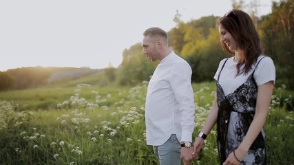 Loving couple holding hands walking in the Park at sunset