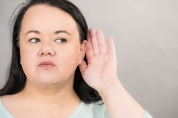 Woman overhearing listening to rumors.
