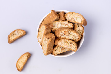 Italian Almond Biscuit Biscotti or Cantuccini in a White Bowl Tasty Italian Dessert for Coffee or Wine Top View Blue Background