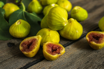 Fresh organic figs on a white plate, on the old wooden table.