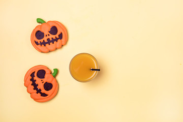 Delicious Ginger Biscuits for Halloween and Pimpkin Juice on Yellow Background Halloween Background Two Gingerbreads in Shape of Pumpkins Horizontal View from Above