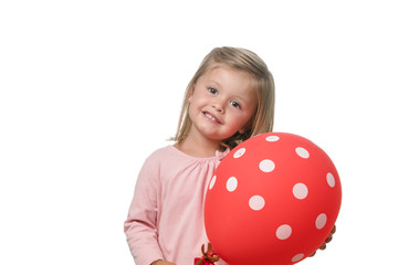 Fototapeta na wymiar Blonde little girl smiling to camera with a balloon on white background