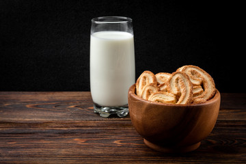 Palmier cookies or puff pastry ears on dark wooden background.