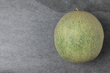 Top view of Melon on concrete table with left space.