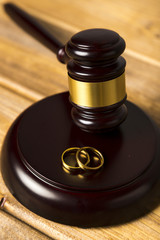 Close-up with judge gavel on stand with wedding rings