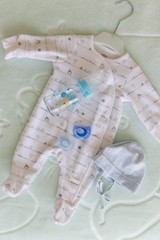 Obraz na płótnie Canvas top view of newborn baby clothes with milk bottle.