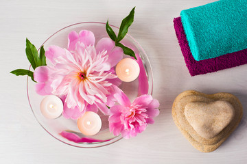 Obraz na płótnie Canvas Composition of spa treatment. Two towels. Peonies and candles in the bowl.
