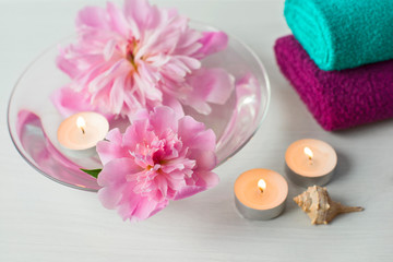 Composition of spa treatment. Peonies and burning candles.