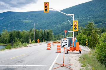 Traffic lights, cones and barriers at the beginning of a construction site along a mountain road on...