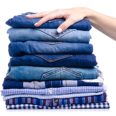 Stack folded casual shirt and jeans holding hand on white background isolation