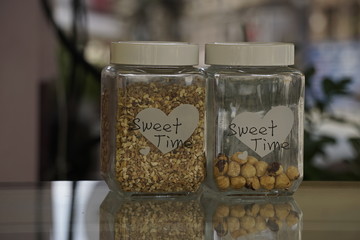 Close up of two jars with hazelnuts on a counter of a store.