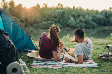 young couple relaxing by the river. camping outdoor