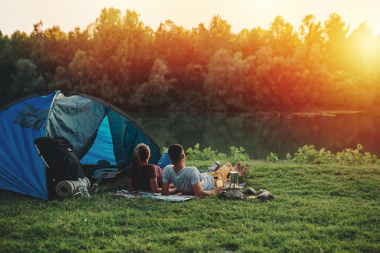 young couple relaxing by the river. camping outdoor