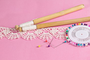 Vologda dimensional lace, flax threads, weaving on bobbins of honeysuckle on a pink background
