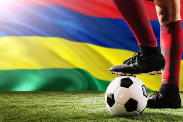 Close up legs of Mauritius football team player in red socks, shoes on soccer ball at the free kick...