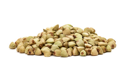 Small flat pile of green buckwheat seen from the side and isolated on white background