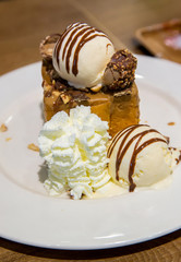 honey toast with vanilla ice cream and whiping cream topped with chocolate sauce on white dish. sweets bread and dessert. high calories from sugar. image for background, wallpaper and copy space.
