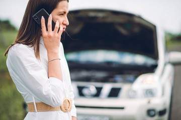 In a young beautiful woman's car was broken during the trip, she tries to call the tow truck