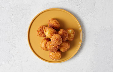 Cottage cheese balls doughnuts is jam-packed with jelly filling on yellow plate