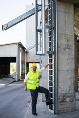 worker in safety equipment climbing on industrial ladders © cherryandbees