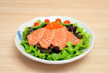 Raw Salmon sashimi with vegetable in ceramic bowl