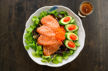 Raw Salmon sashimi with vegetable in ceramic bowl