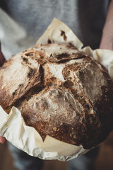 Pan de masa madre - Pan de masa fermentada en manos de hombre