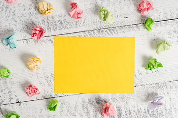 Crumpled colored rectangle square shaped paper reminder white wood desk