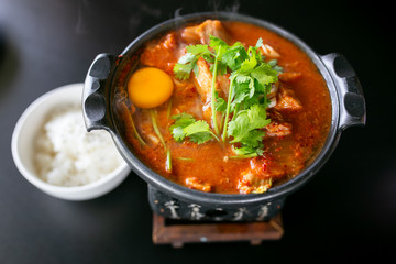 Kimchi soup with raw chicken eggs and white tofu, popular Korean food.