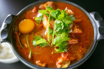 Kimchi soup with raw chicken eggs and white tofu, popular Korean food.