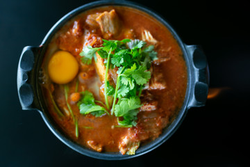 Kimchi soup with raw chicken eggs and white tofu, popular Korean food.