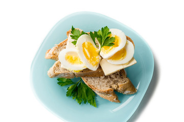 Fried Egg on Toast for Breakfast. Fried egg with bread and parsley on white plate on black, top view, copy space.