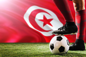 Close up legs of Tunisia football team player in red socks, shoes on soccer ball at the free kick...