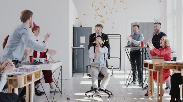 RED EPIC Happy young boss celebrates success with colleagues team and confetti at multiethnic modern office slow motion.