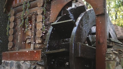 Water Flows and Spins Wooden Wheel of the Decorative Mill, slow motion, slow motion.