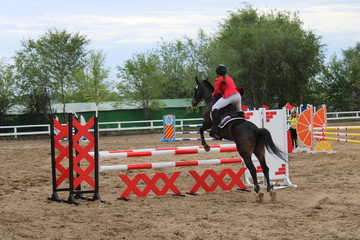 young girl riding a horse jump