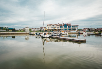 City pier with many sailing yachts