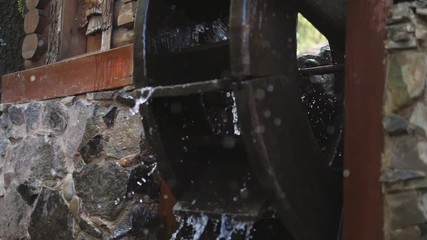 Slow motion shooting water flows on a decorative water mill in the Park.