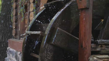 Water Flows and Spins Wooden Wheel of the Decorative Mill, slow motion, slow motion.