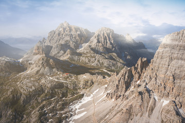 majestic aerial view of dolomites mountains in the three peaks of lavaredo national park at sunset on a misty day. scenic landscape of mountains in south tyrol, north italy, europe.